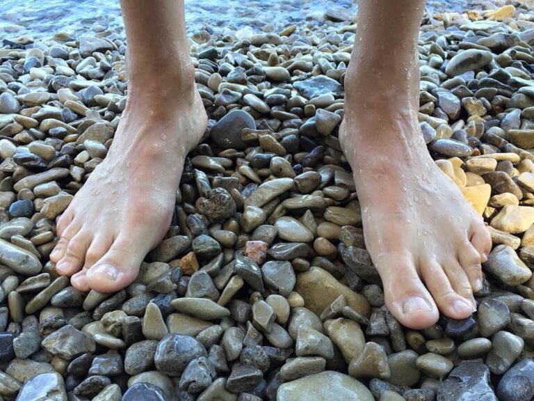 Man's feet on pebbles