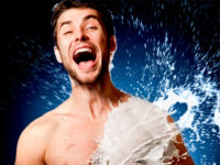 Emotional shirtless man splashed with white liquid