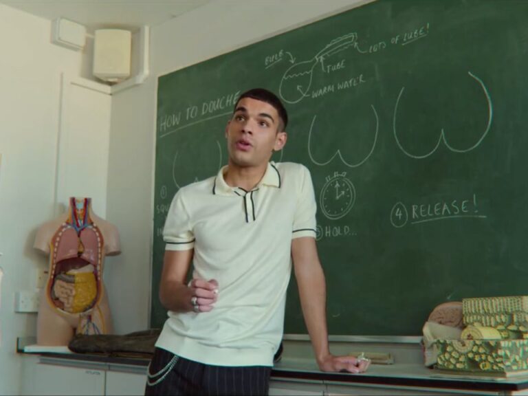 Young man teaching douching at chalkboard