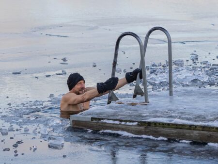 Shirtless man exiting icy water